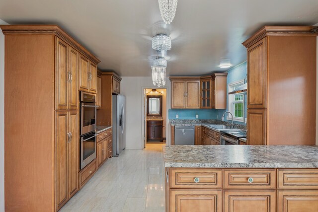 kitchen featuring pendant lighting, stainless steel appliances, kitchen peninsula, and sink