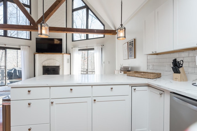 kitchen with a peninsula, white cabinetry, open floor plan, dishwasher, and tasteful backsplash