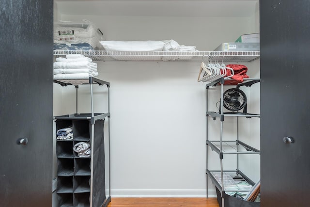 walk in closet with wood finished floors