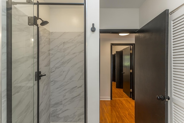 bathroom featuring a shower stall and wood finished floors