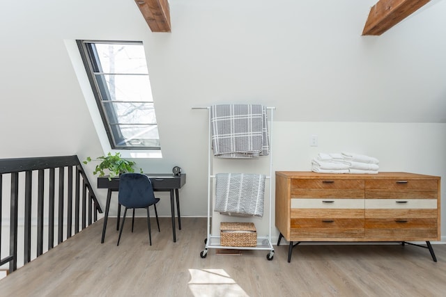 interior space featuring vaulted ceiling with beams, plenty of natural light, and wood finished floors