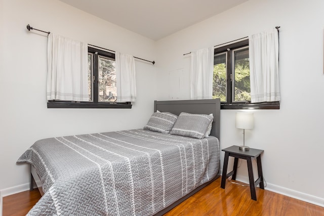 bedroom with baseboards and wood finished floors