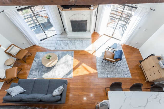 living area featuring a fireplace, baseboards, and wood finished floors