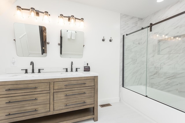 full bath with bath / shower combo with glass door, visible vents, a sink, and double vanity