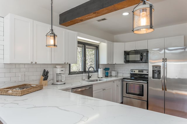 kitchen with stainless steel appliances, white cabinetry, a sink, and tasteful backsplash