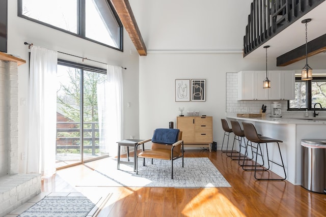 interior space featuring high vaulted ceiling, wood finished floors, and beam ceiling