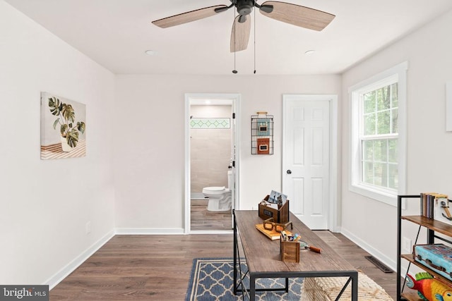 interior space featuring baseboards, ceiling fan, dark wood-style floors, and visible vents