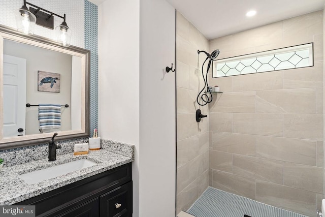 bathroom with vanity and tiled shower