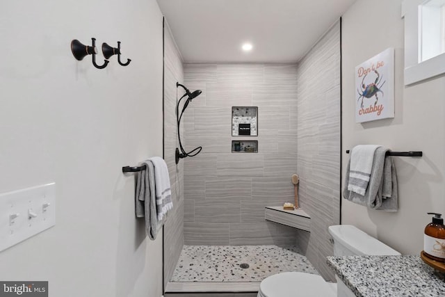 bathroom with vanity, recessed lighting, toilet, and tiled shower