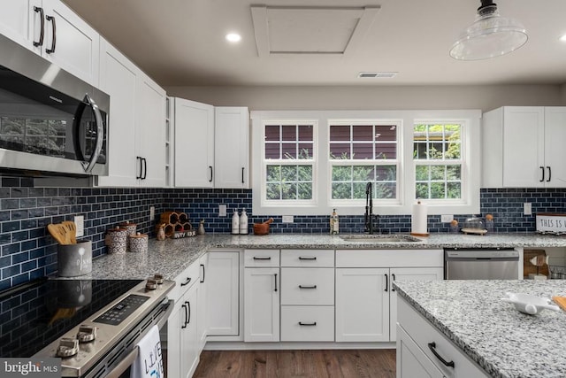 kitchen featuring stainless steel appliances, visible vents, white cabinetry, and a sink