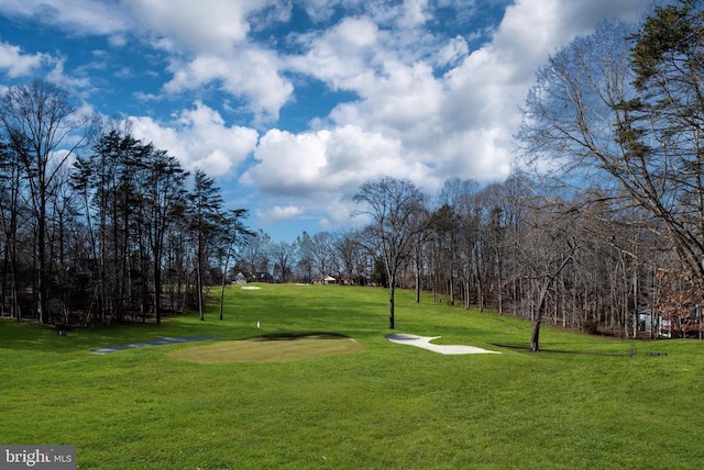 surrounding community featuring a lawn and view of golf course