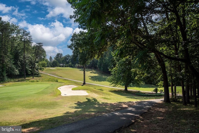 view of community with view of golf course and a yard