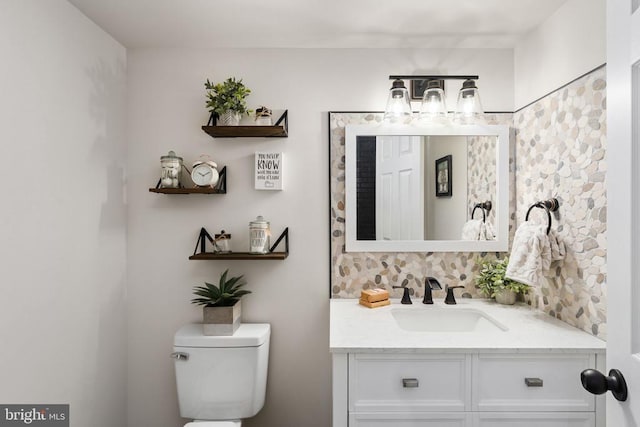 bathroom with vanity, backsplash, and toilet
