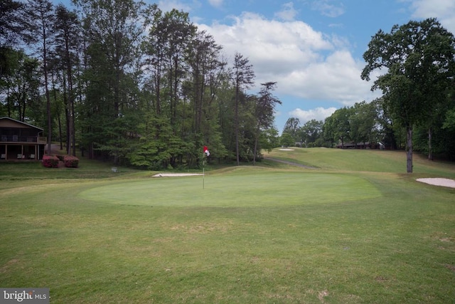 view of property's community with a lawn and view of golf course