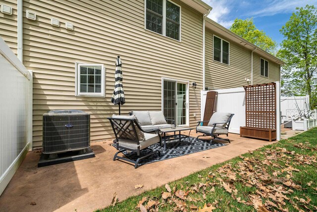 rear view of property featuring fence, central AC, a patio, and an outdoor hangout area