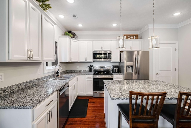 kitchen featuring a sink, dark wood-type flooring, a breakfast bar area, white cabinets, and appliances with stainless steel finishes