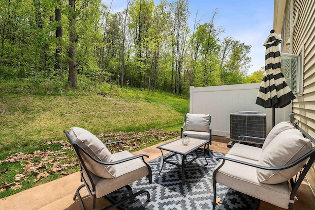 view of patio / terrace featuring a wooded view and cooling unit