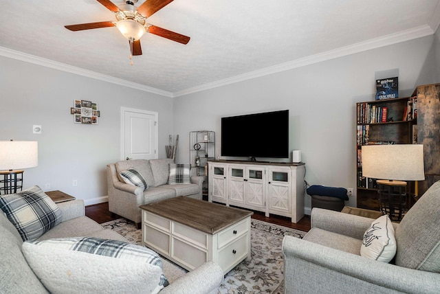 living area featuring baseboards, ornamental molding, and a ceiling fan