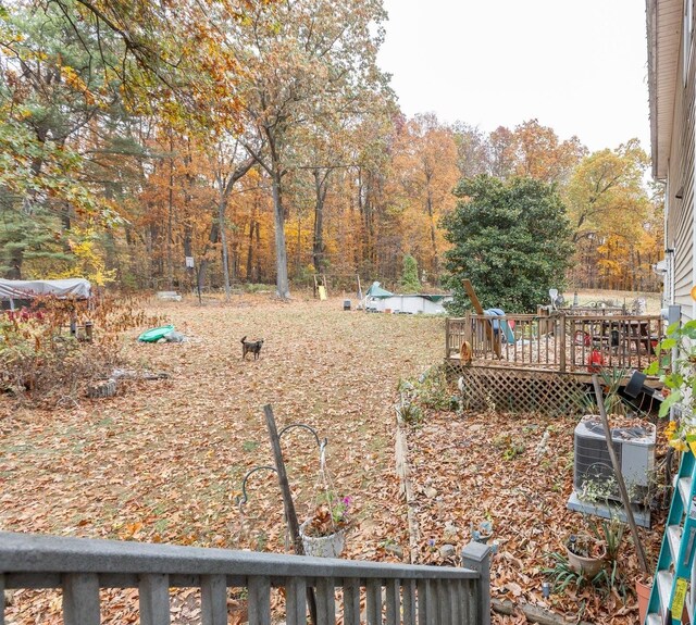 view of yard featuring central AC and a deck