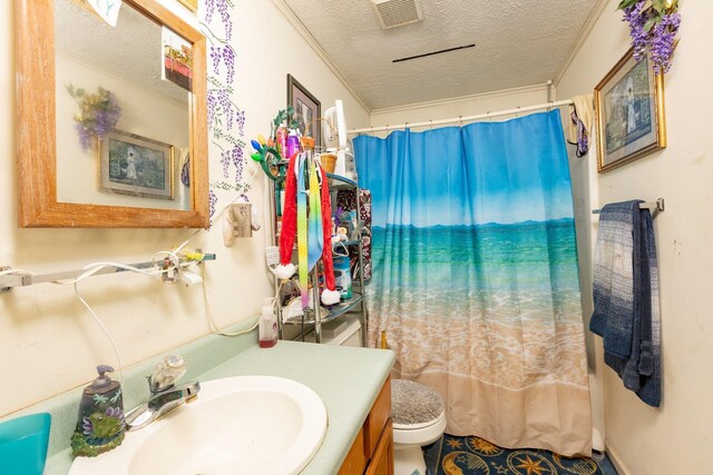 bathroom featuring toilet, a textured ceiling, ornamental molding, vanity, and curtained shower