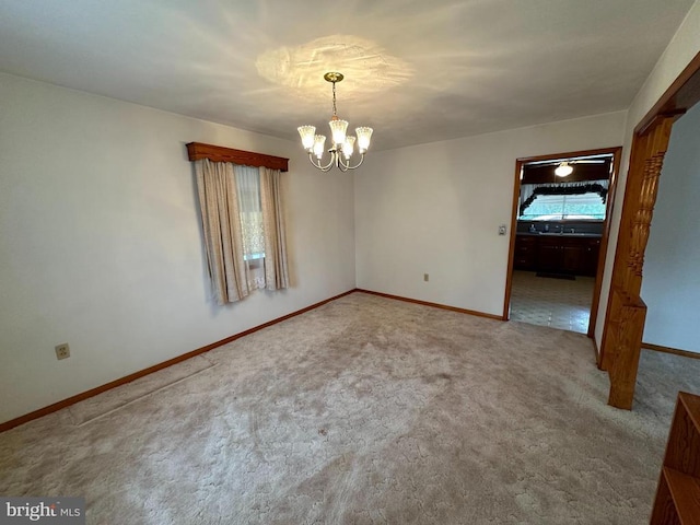 unfurnished room featuring a chandelier and carpet