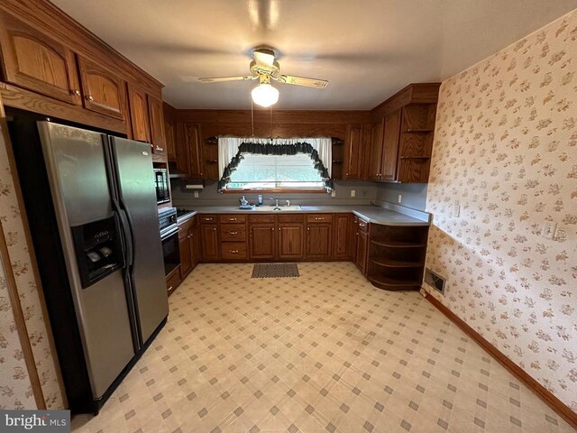 kitchen with oven, sink, stainless steel fridge, and ceiling fan