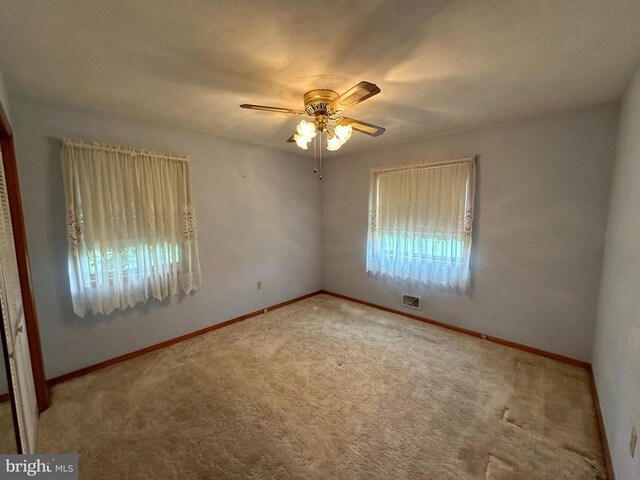 empty room with ceiling fan and carpet flooring