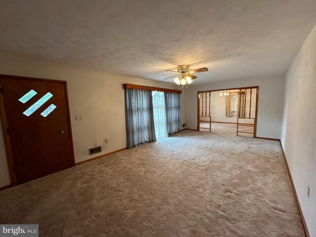 interior space with light carpet and ceiling fan