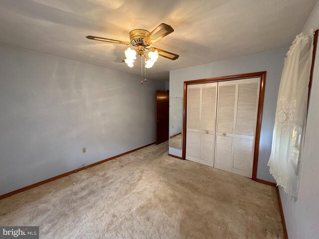 unfurnished bedroom with a closet, ceiling fan, and carpet flooring