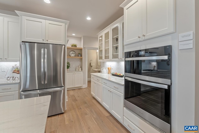 kitchen featuring appliances with stainless steel finishes, white cabinetry, light wood-style flooring, and open shelves