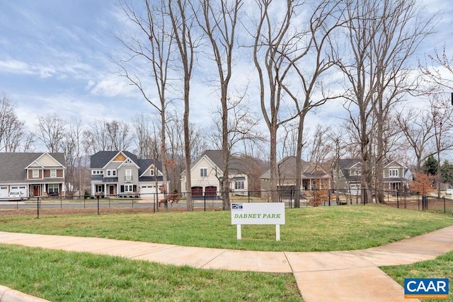 view of property's community with a yard, fence, and a residential view