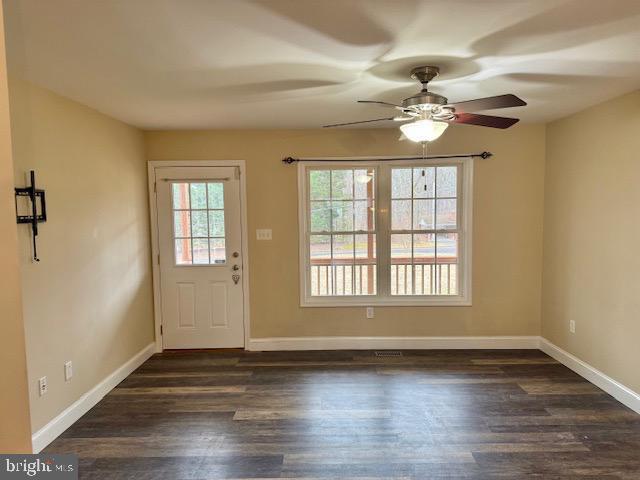 entryway with ceiling fan, baseboards, and dark wood-style floors