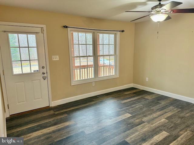 entryway with a ceiling fan, dark wood-style flooring, and baseboards