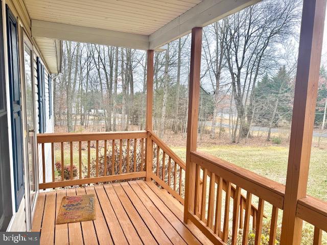 wooden terrace with a lawn