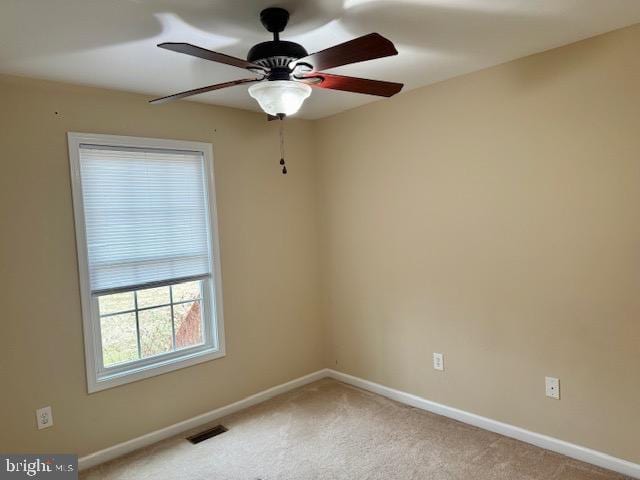 unfurnished room with visible vents, carpet flooring, baseboards, and ceiling fan