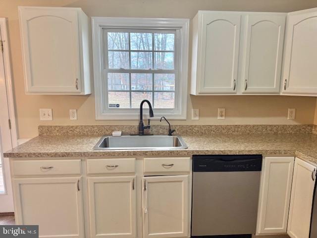 kitchen featuring a sink, white cabinetry, light countertops, and stainless steel dishwasher