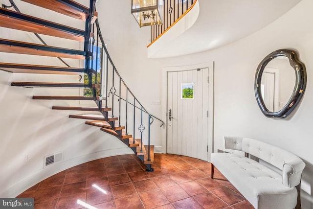 foyer entrance featuring tile patterned flooring and a high ceiling