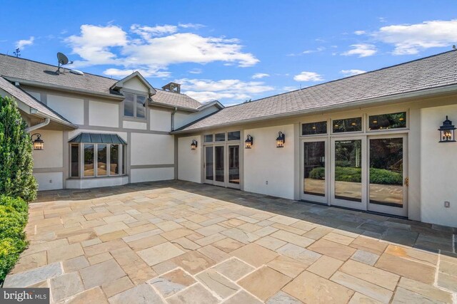 back of property with a patio area and french doors