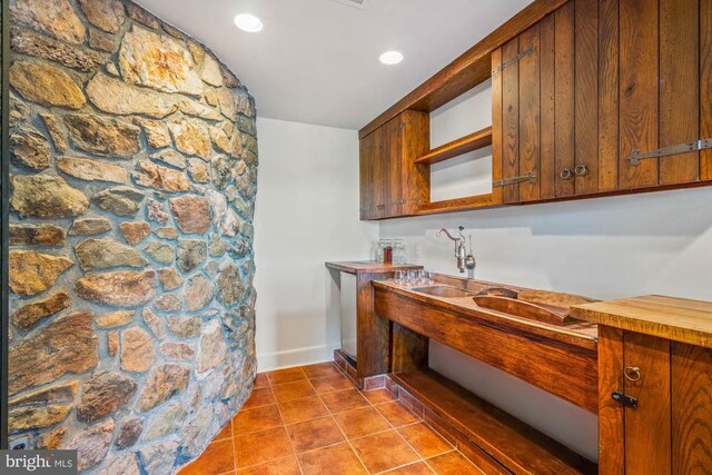 kitchen featuring light stone counters, sink, beamed ceiling, and appliances with stainless steel finishes