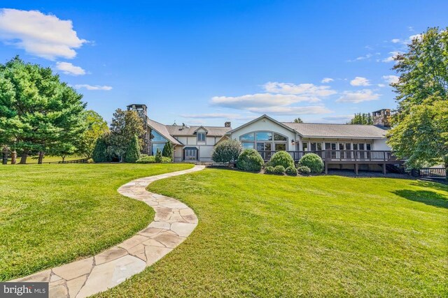 single story home with a wooden deck and a front lawn