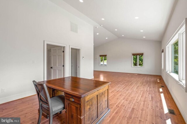 home office with light hardwood / wood-style flooring and high vaulted ceiling