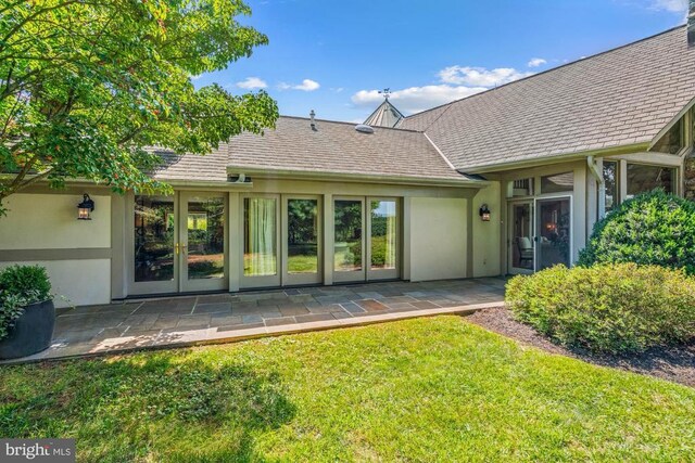 rear view of property with french doors, a yard, and a patio area