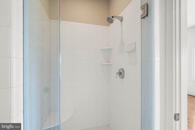 bathroom featuring a shower with door and wood-type flooring