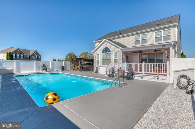 view of swimming pool featuring pool water feature, ceiling fan, and a patio area