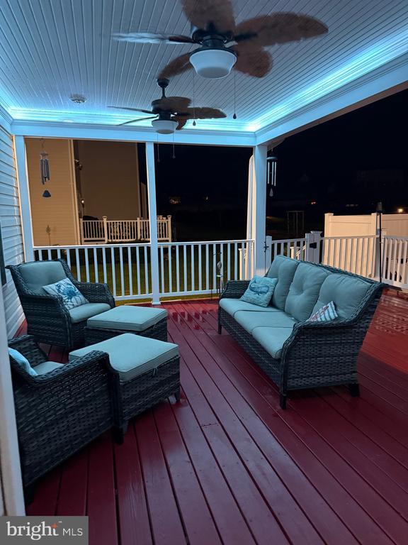 wooden terrace featuring an outdoor living space and ceiling fan