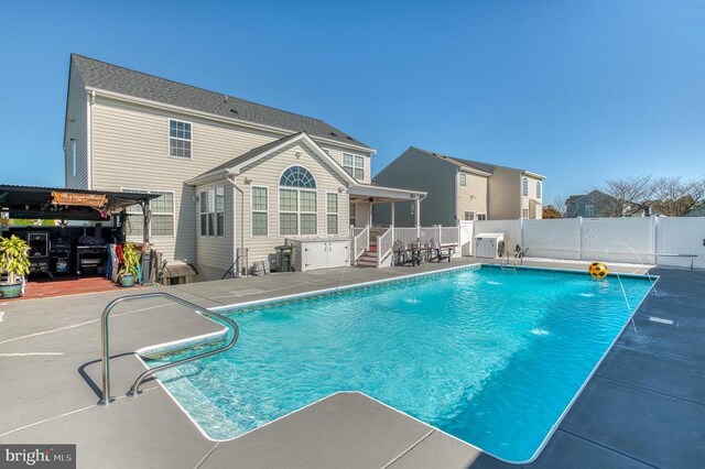 view of swimming pool with pool water feature, a pergola, and a patio area