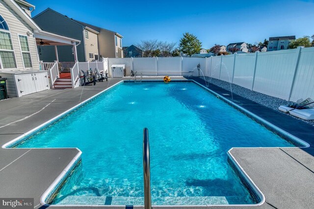 view of swimming pool with pool water feature and a patio area