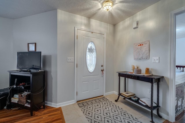 tiled entryway with a textured ceiling