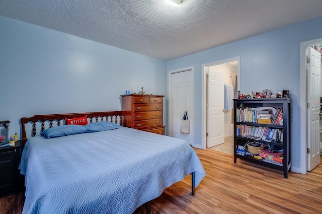 bedroom featuring a closet, light hardwood / wood-style floors, and a textured ceiling