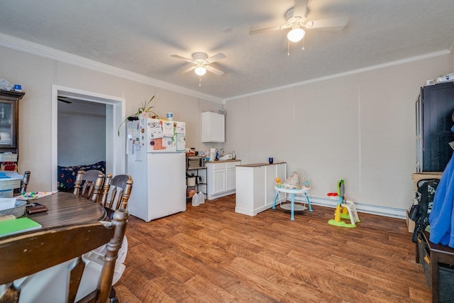 dining area with ceiling fan, ornamental molding, and light hardwood / wood-style flooring